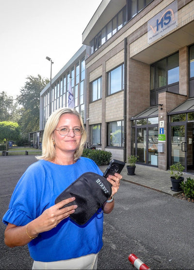 Medewerker met ’t Zakkie voor een schoolgebouw